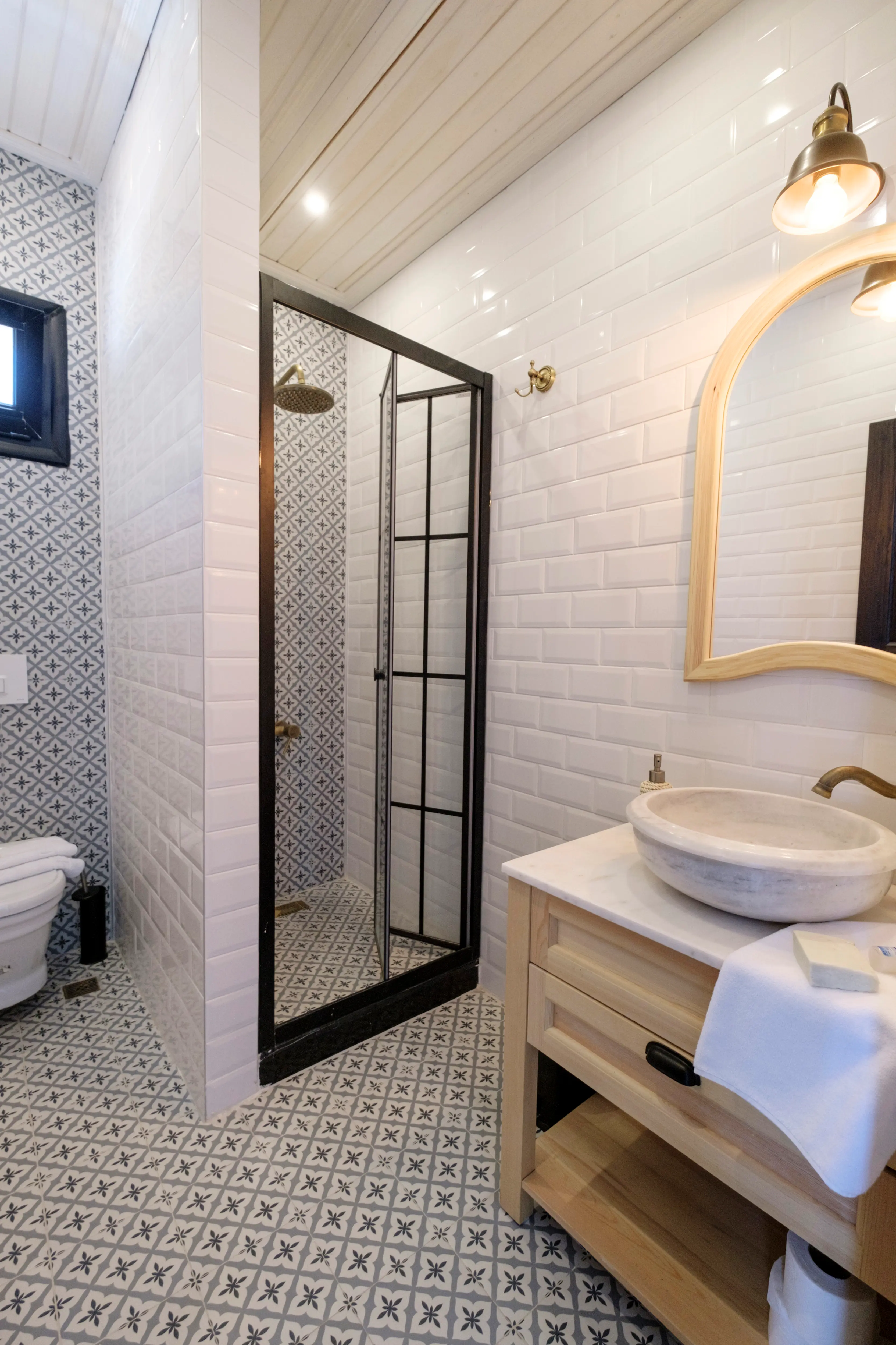 Blue room bathroom with patterned floor tile, a stone basin and a shower