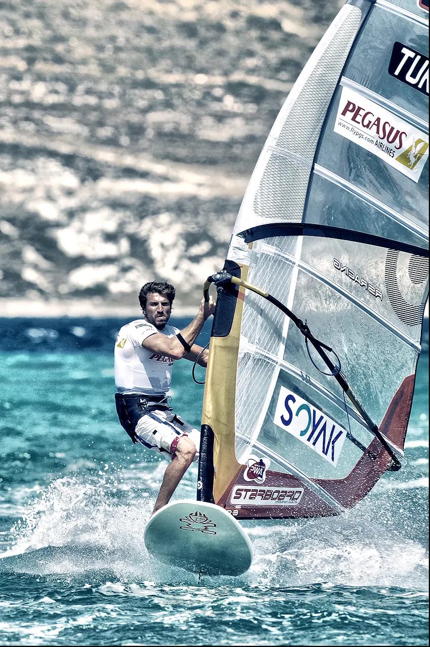 Bora Kozanoğlu windsurfing across turquoise water at Alaçatı, near Cesme