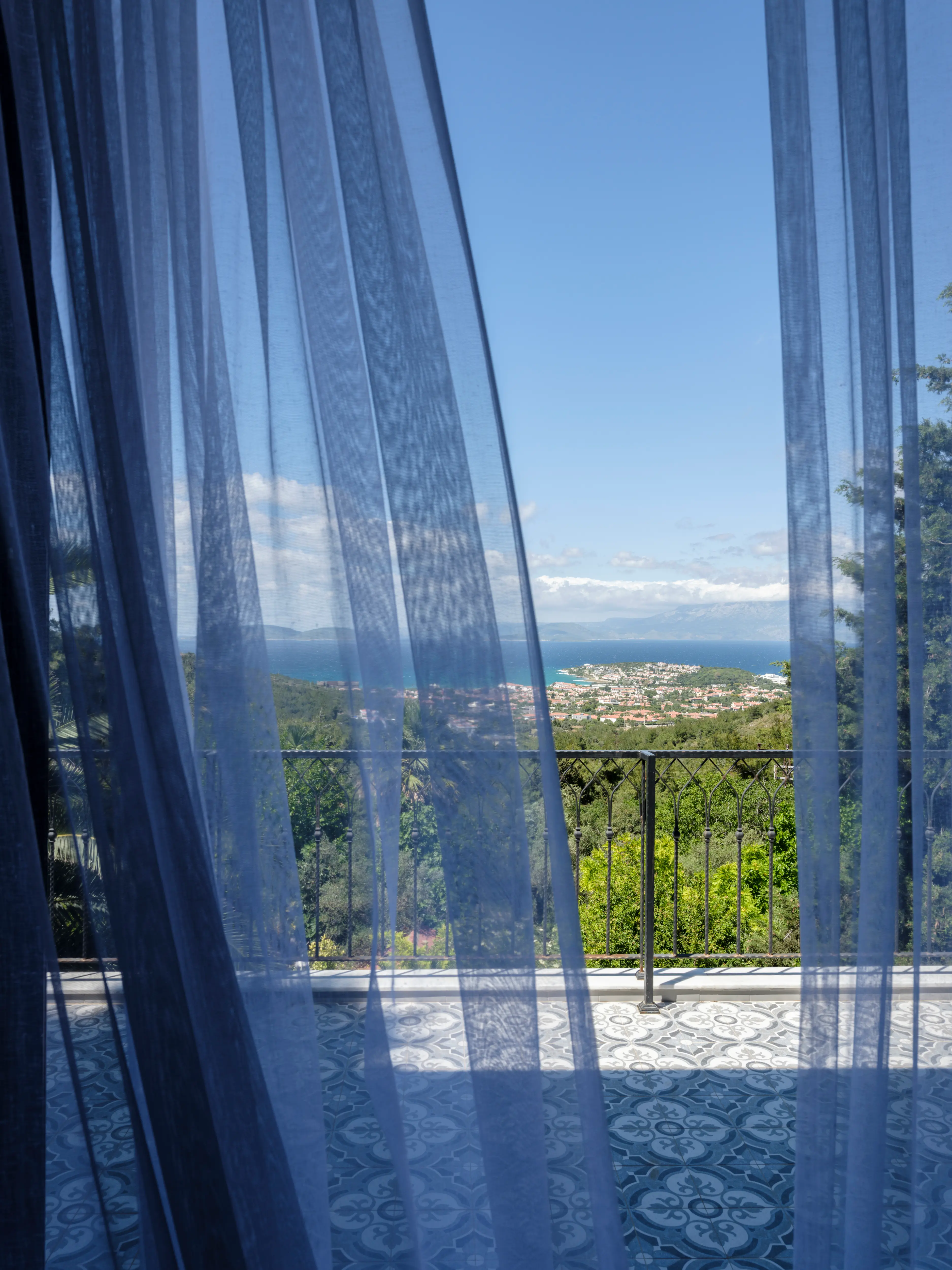 Terrace room with a sheer curtain opening onto a balcony and sea view
