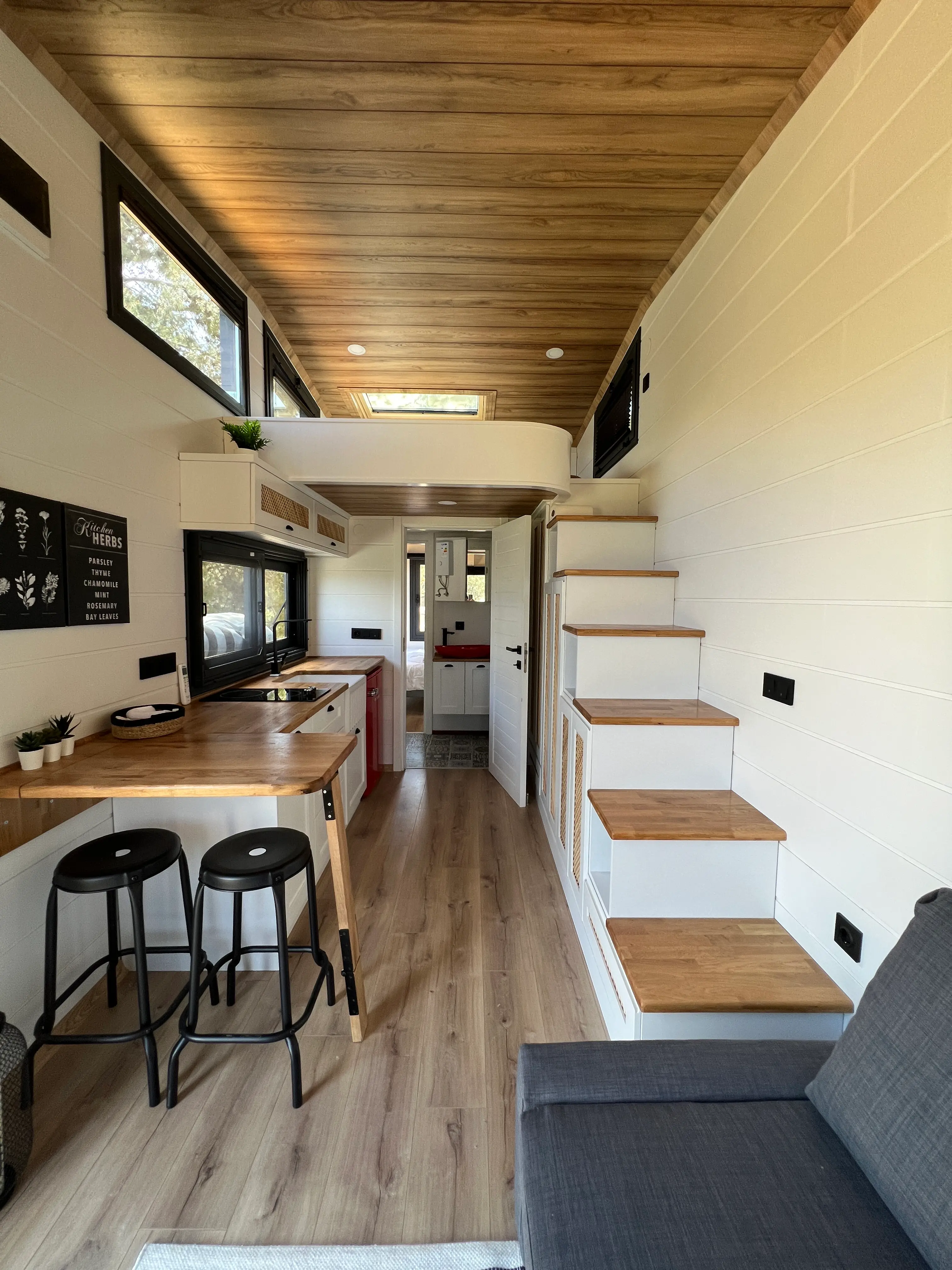 Tiny house interior along the kitchen bar toward the loft stairs