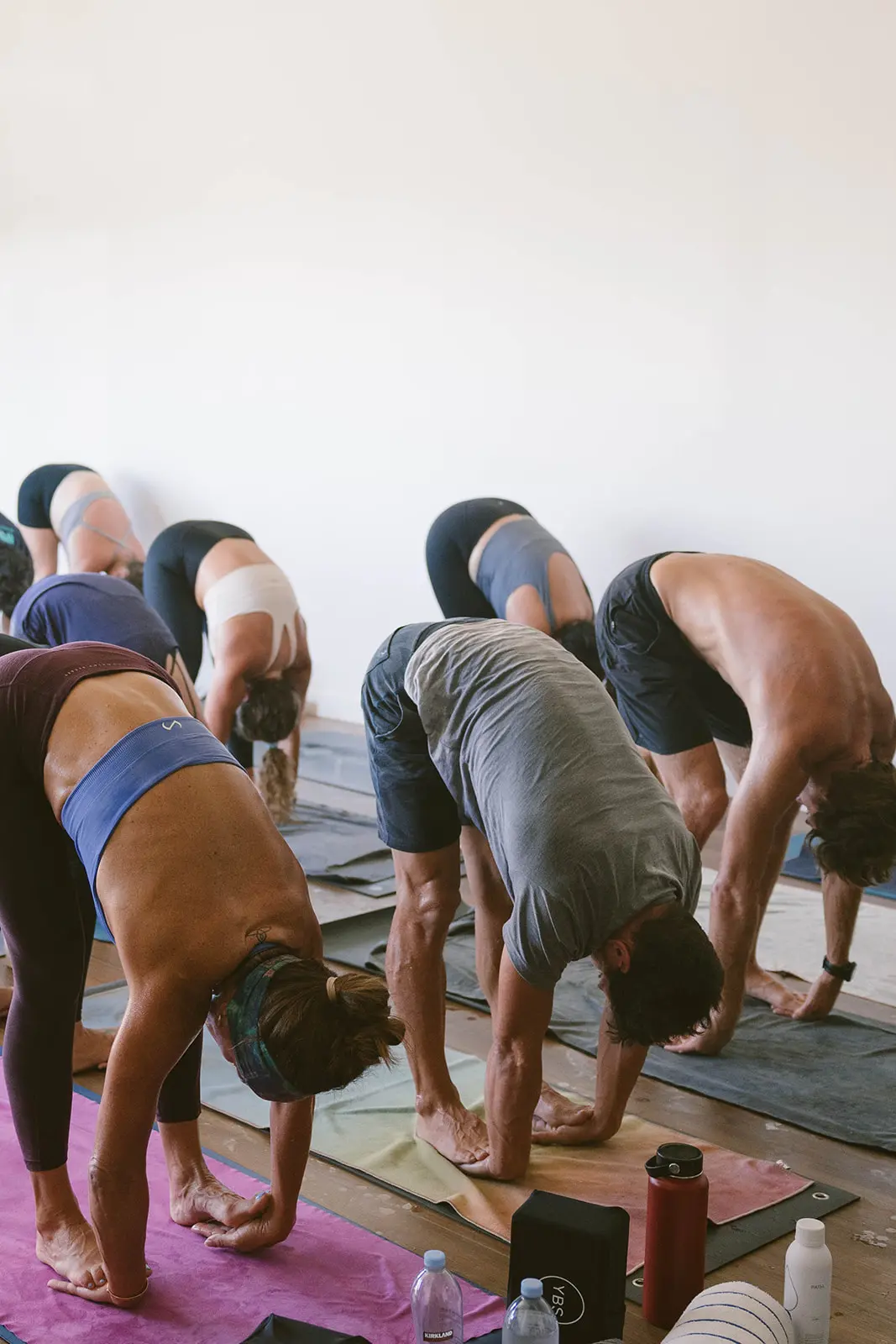 Group of yoga students in forward fold at Kahului studio